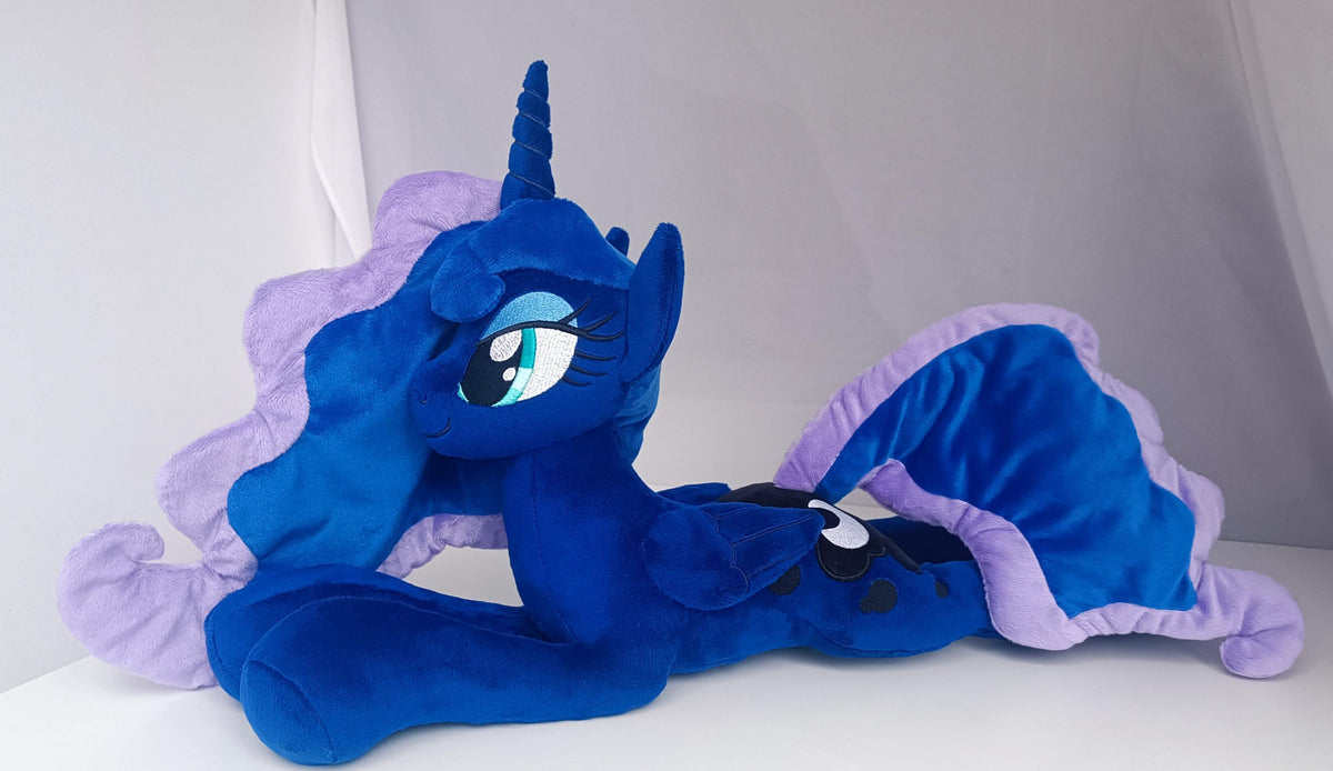 Side view of lying Princess Luna plush toy with large wings and soft pastel mane.